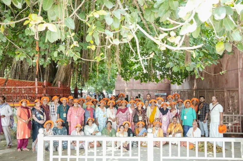 The whole travel group gathered beneath a large banyan tree at a temple