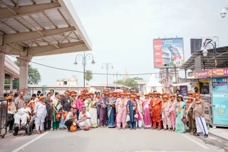 Pilgrims with saffron scarves posing together outside the Ayodhya temple gate